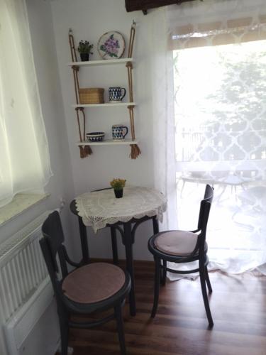 a small table and two chairs in a room with a window at Małopolskie Swojskie in Olszyny