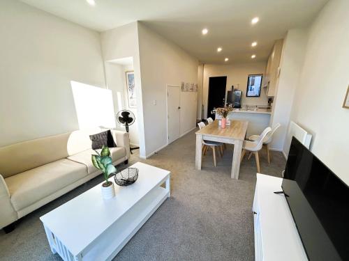 a living room with a couch and a table at Entire Modern 2-Bedroom Townhouse -10 min to Airport & Sylvia Park in Auckland