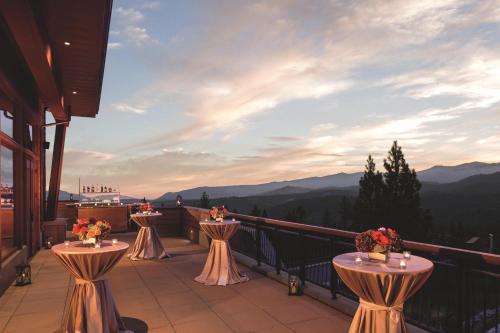 a balcony with two tables and a view of the mountains at The Ritz-Carlton, Lake Tahoe in Truckee