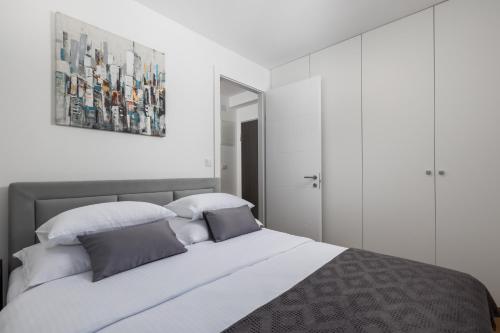 a bedroom with a large white bed with two pillows at Luxury apartment Mon Soleil 2 in Murter