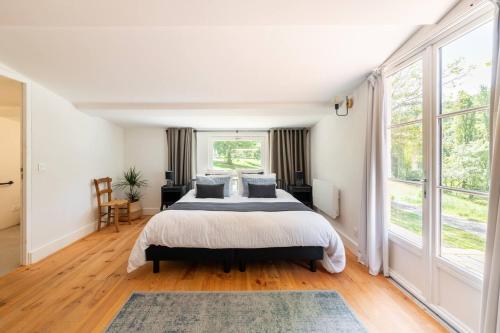 une chambre avec un lit et une grande fenêtre dans l'établissement Gîte de Fompesquiere, à Frespech