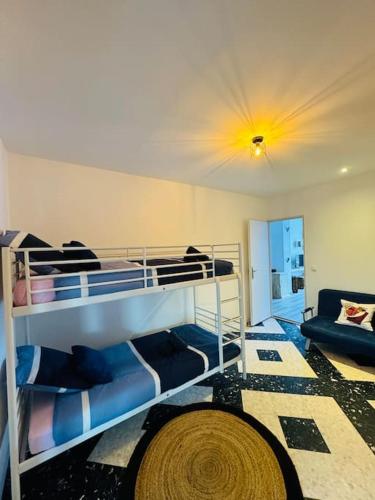 une chambre avec deux lits superposés et un canapé dans l'établissement Lou Maluma, à Saint Alban Auriolles