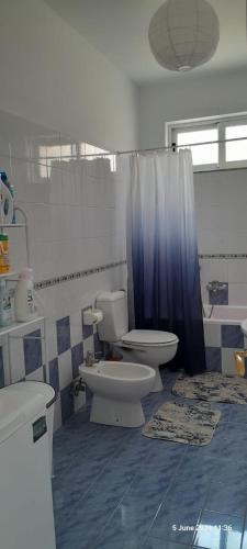 a bathroom with two toilets and a sink and a shower at Liv Skyline Apartment in Sarandë