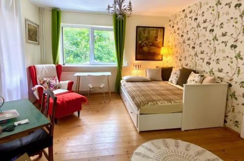 a living room with a bed and a couch at Studio im Haus Amselgarten in Kolonie Tannenhof