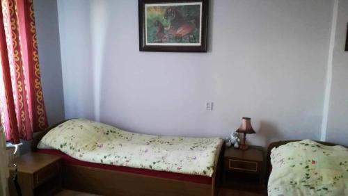 a small bedroom with a bed and a picture on the wall at Dom Pod Gruszą in Chmielno