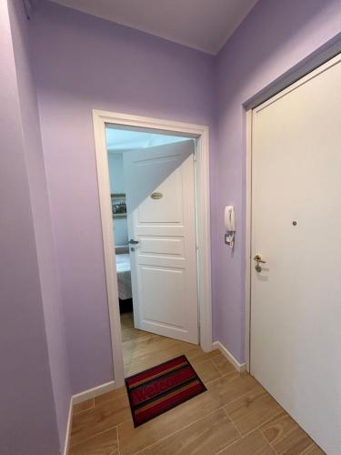 a hallway with purple walls and a white door at Etrusco Viola - Suite Giglio Rosso in Bagno a Ripoli