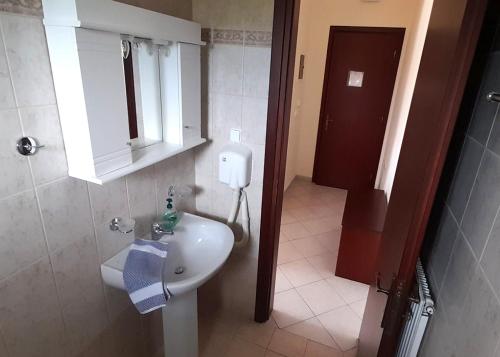 a bathroom with a white sink and a toilet at Kastri Hotel in Néa Meságkala