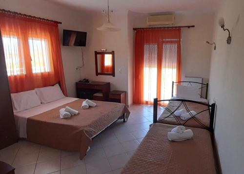 a bedroom with two beds with towels on them at Kastri Hotel in Néa Meságkala