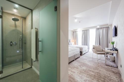 a hotel room with a shower and a bedroom at Fabesca Boutique Hotel & SPA in Sovata