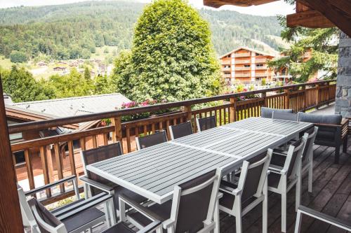 a table and chairs on the deck of a balcony at Les Chalets d'Adelphine & SPA in Les Gets