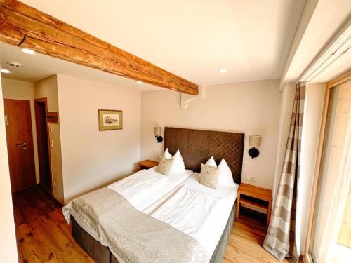 a bedroom with a large bed with white sheets at Hotel Pass Lueg in Golling an der Salzach