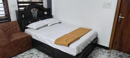 a bed with a brown blanket on top of it at Dream Nest Villa Wayanad in Kalpetta