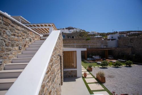 a staircase leading up to a house with a stone wall at VILLA PANAMERA Mykonos, Private Heaven, Supreme View! in Fanari