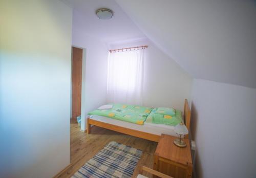 a small bedroom with a bed and a table at Juhfark Fogadó és Borház in Balatoncsicsó