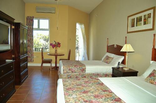 a hotel room with two beds and a table at Guest House Villa Mishkan in Runaway Bay
