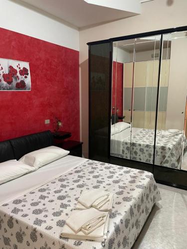 a bedroom with a bed and a red wall at Casa Ale in Avola