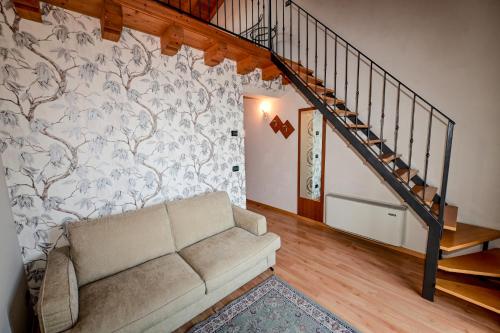 a living room with a couch and a staircase at Hotel La Fenice e Sole in Tremosine Sul Garda