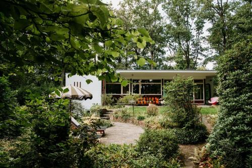 a house with a garden in front of it at Bungalowvilla Robin Hill, met bostuin & design interieur in Haelen
