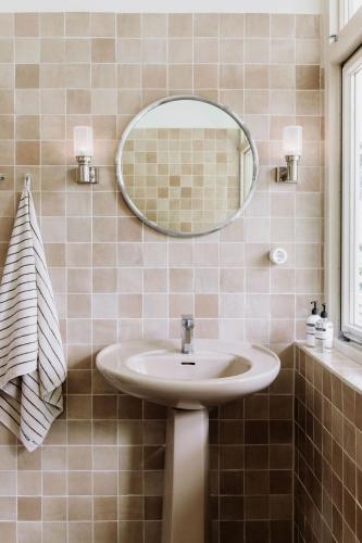 a bathroom with a sink and a mirror at Bungalowvilla Robin Hill, met bostuin & design interieur in Haelen