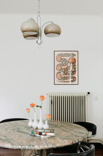 a dining room table with vases and flowers on it at Bungalowvilla Robin Hill, met bostuin & design interieur in Haelen