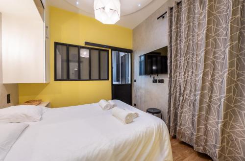 une chambre avec un lit blanc et des murs jaunes dans l'établissement Full-Equipped & Near to Subway, à Paris