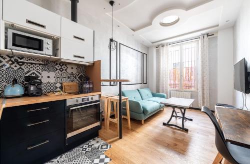 - une cuisine et un salon avec un canapé bleu et une table dans l'établissement Full-Equipped & Near to Subway, à Paris