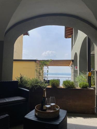 a patio with a table with wine glasses on it at Terrazza sulle mura Appartamento Sole in Predore