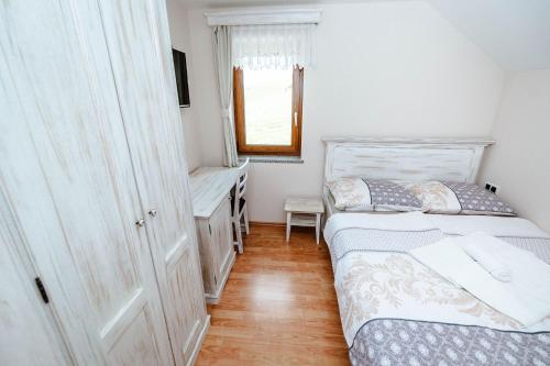 a small bedroom with a bed and a desk at Zelena Oaza - B&B in Miklavž pri Ormožu