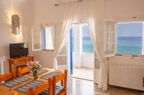a room with a table and a view of the ocean at ILIOS in Perlopsimades