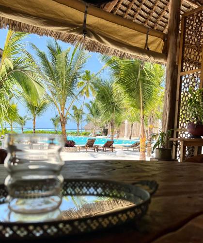 a glass bowl on a table with a view of the ocean at Infinity Beach Boutique Hotel & SPA in Matemwe