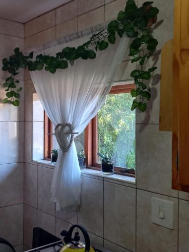 a window with a white curtain in a kitchen at Rietjie Se Plekkie in Amanzimtoti