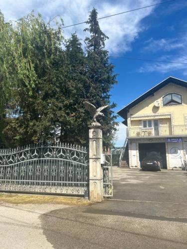 a gate with a bird statue in front of a house at Astralis Factory Apartments- FLY in Zagreb
