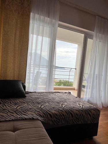 a bedroom with a bed and a large window at Apartment Becici Sunset 3 in Becici