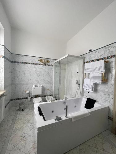 a white bathroom with a tub and a toilet at Hotel Villa La Bollina in Serravalle Scrivia