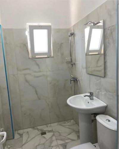 a bathroom with a sink and a toilet and a mirror at Kompleksi Tre Shqiponjat in Velipojë