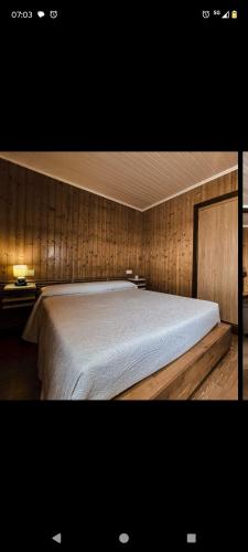 a bedroom with a large bed with wooden walls at Playa de Seiruga in Malpica