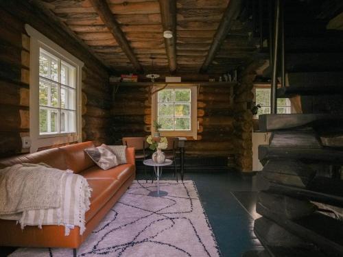 a living room with a couch in a log cabin at Panga Sauna Hut in Lähtru