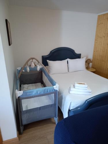 a baby crib sitting next to a bed at Playa de Seiruga in Malpica