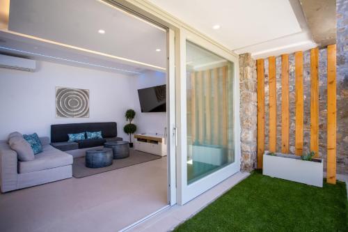 a living room with a couch and a tv at VILLA PANAMERA Mykonos, Private Heaven, Supreme View! in Fanari