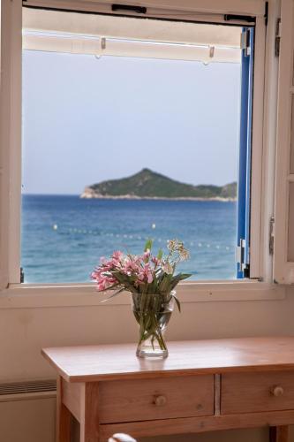 a vase of flowers sitting on a table in front of a window at ILIOS in Perlopsimades