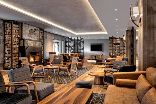 a lobby with chairs tables and a fireplace at Four Points by Sheraton Bansko in Bansko