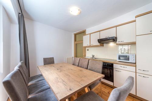 a kitchen with a wooden table and chairs at Central Apartments Cristlpek in Ortisei