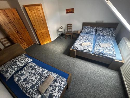 a bedroom with two beds and a staircase at Restaurace a penzion Na Stráni in Klášterec nad Orlicí