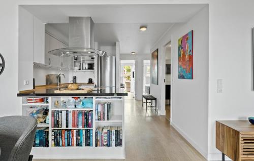 a kitchen with a book shelf filled with books at Beach Front Apartment In Nykøbing Sj in Nykøbing Sjælland