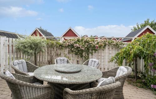 a patio with a table and chairs and a fence at Beach Front Apartment In Nykøbing Sj in Nykøbing Sjælland