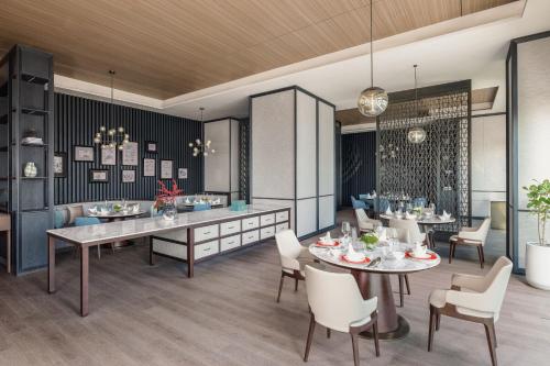 a dining room with a table and chairs at Qingdao Marriott Hotel Jiaozhou in Qingdao