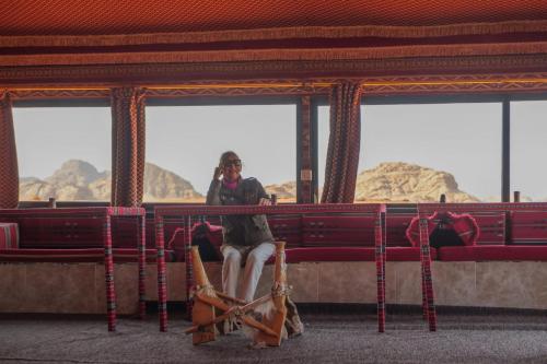a person sitting on a bench in a theatre at Wadi Rum Desert Adventures in Wadi Rum