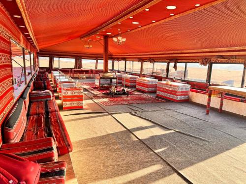 a deck of a cruise ship with red chairs and tables at Wadi Rum Desert Adventures in Wadi Rum