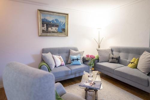 a living room with two couches and a table at Chasa Valbernard in Vulpera