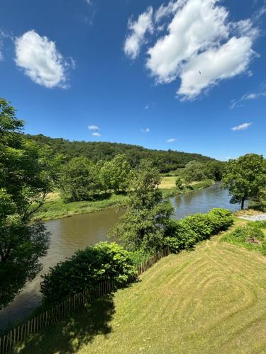 a view of a river with a fence and trees at Penthouse : immersion dans la nature in Durbuy